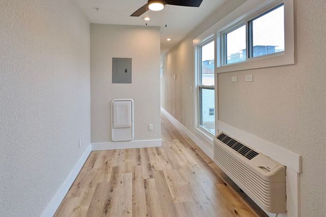 Living area with ceiling fan and windows
